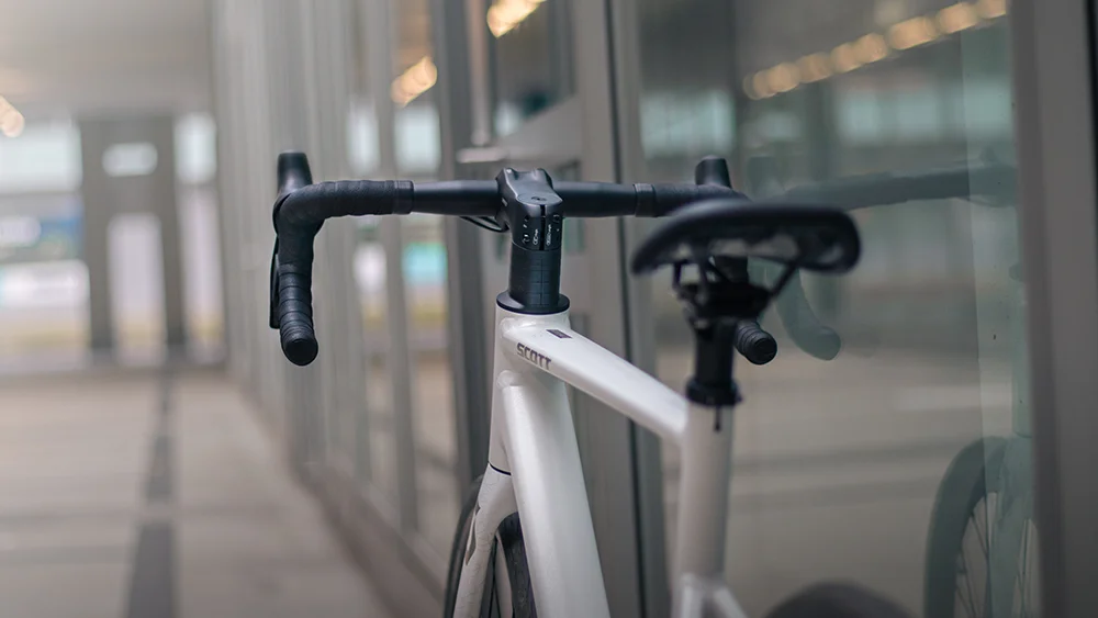 Ganzaufnahme des wei&szlig;en SCOTT Contessa Fahrrads vor moderner Architektur