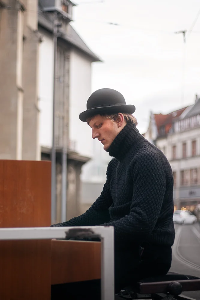 Seitliche Aufnahme des Pianisten beim Spielen in der Innenstadt